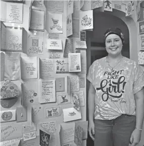  ?? KAREN SCHIELY, AKRON BEACON JOURNAL ?? Tori Potemski stands in her home next to cards of encouragem­ent from family and friends as she is undergoing treatment for breast cancer Tuesday, Oct. 27, 2020 in Akron, Ohio.