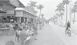  ??  ?? Cafe tables are now allowed to spill farther out on the Hollywood Beach Broadwalk.