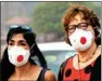  ?? PTI ?? Tourists wear anti-pollution masks amid heavy smog, at Rajpath in New Delhi, on Friday