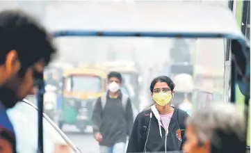  ??  ?? An Indian resident wearing a facemask walks amid heavy smog in New Delhi. — AFP photo