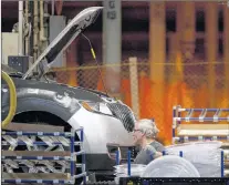  ?? THE CANADIAN PRESS/CHRIS YOUNG ?? A line worker works on a car at Ford Motor plant in Oakville, Ont., in 2013.