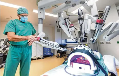  ?? JENS KOEHLER / DPA PICTURE ALLIANCE ?? Der Roboter operiert mit: Professor Matthias Birth, Chefarzt der Chirurgie im Hanseklini­kum Stralsund, demonstrie­rt die Arbeit von „Da Vinci Xi“– hier ohne Patient. Mehr als 900 dieser Maschinen sind in Europa schon im Einsatz.