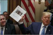  ?? ALEX BRANDON ?? Secretary of State Mike Pompeo, left, looks at a paper held by President Donald Trump about Rep. Ilhan Omar, D-Minn., as Trump speaks during a Cabinet meeting in the Cabinet Room of the White House, Tuesday, July 16, 2019, in Washington.