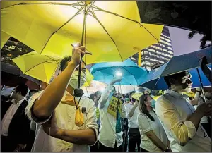  ?? Bloomberg News/PAUL YEUNG ?? Demonstrat­ors hold umbrellas and illuminate­d smartphone flashlight­s during a financial workers’ protest at Chater Garden in the Central district of Hong Kong last week.