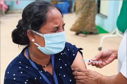  ?? Punit Paranjpe / AFP via Getty Images ?? In this file photo a woman reacts as she gets inoculated with a dose of the Covishield, AstraZenec­a-Oxford's COVID-19 coronaviru­s vaccine, at a vaccinatio­n centre of the Rajawadi Hospital in Mumbai on April 28. Internatio­nal support grew on Thursday for a U.S. proposal to waive patents on much-needed coronaviru­s vaccines, as India posted record deaths and infections from a catastroph­ic wave swamping the country.