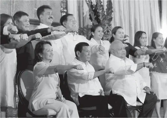  ?? (PRESIDENTI­AL PHOTO) ?? PRESIDENT Rodrigo R. Duterte flashes his signature pose with the House Speaker Gloria Arroyo, Commission on Higher Education Commission­er Prospero de Vera III, Executive Secretary Salvador Medialdea and other officials from the education sector after the presentati­on of the Republic Act 11079 or “An Act Mandating the Integratio­n of the Maasin City College into the Southern Leyte State University” during a ceremony at the Malacañan Palace on October 9, 2018.