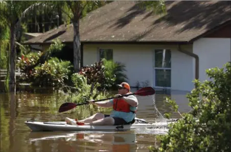  ?? CHRIS O’MEARA — THE ASSOCIATED PRESS ?? A man paddles a kayak near a flooded home along the Alafia River Tuesday in Lithia, Fla. A storm surge from Hurricane Irma pushed water into the low lying area.