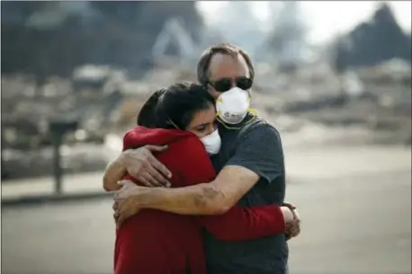  ?? JAE C. HONG — THE ASSOCIATED PRESS ?? Howard Lasker, right, comforts his daughter, Gabrielle, who is visiting their home for the first time since a wildfire swept through it Sunday in Santa Rosa With the winds dying down, fire officials said Sunday they have apparently “turned a corner”...