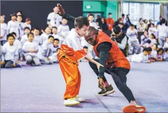  ?? PROVIDED TO CHINA DAILY ?? Kenya’s Eliud Kipchoge, who holds the world record in marathon, learns a kung fu move from a young student at the Active School PE program at Zhongguanc­un No 3 Elementary School in Beijing on Wednesday.