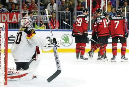  ??  ?? Geschlagen: Torwart Philipp Grubauer kniet auf dem Eis, während die kanadische­n Spieler über ihren zweiten Treffer beim Viertelfin­ale in Köln jubeln. Foto: Wolfgang Rattay/Reuters