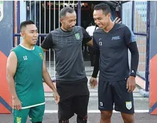  ?? ANGGER BONDAN/JAWA POS ?? GENG SIDOARJO: Uston Nawawi (tengah) menyapa Rendi Irwan (kiri) dan Lucky Wahyu setelah sesi latihan resmi di Stadion Surajaya, Lamongan, kemarin (22/10).