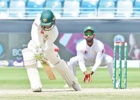  ?? — AFP photo ?? Australian cricketer Usman Khawaja (L) plays a shot during the fifth day of play of the first Test cricket match in the series between Australia and Pakistan at the Dubai Internatio­nal Stadium in Dubai on October 11, 2018.