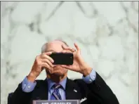  ?? The Associated Press ?? SOCIAL MEDIA: Sen. Chuck Grassley, R-Iowa, uses his smartphone on Oct. 12 during a hearing on Capitol Hill in Washington. Researcher­s from NATO StratCom, a NATO-accredited research group based in Riga, Latvia, paid three Russian companies 300 euros ($368) to buy 337,768 fake likes, views and shares of posts on Facebook, Instagram, Twitter, YouTube and TikTok, including content from verified accounts of Senators Grassley and Chris Murphy. Both senators consented to participat­e.
