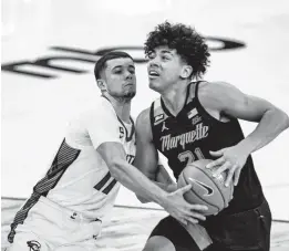  ?? JOHN PETERSON/ASSOCIATED PRESS ?? Marquette guard D.J. Carton, right, drives to the basket against Creighton guard Marcus Zegarowski on Monday night in Omaha, Nebraska.