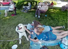  ?? SARAH GORDON/THE DAY ?? Lily Armstrong, 16, pets her dog Journey, 11 months, in training to be a service dog, as her sister Megan Armstrong, 14, sings along with a hymn during a service on Sunday at St. Mark Lutheran Church in Norwich.