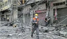  ?? Picture: SUHAIB SALEM/REUTERS ?? REDUCED TO RUBBLE: A Palestinia­n electricit­y worker walks at the site where a tower building was destroyed by Israeli air strikes in Gaza City yesterday, amid a flareup of IsraeliPal­estinian violence