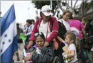  ?? HANS-MAXIMO MUSIELIK — THE ASSOCIATED PRESS ?? Members of a Central American family traveling with a caravan of migrants prepare to cross the border and apply for asylum in the United States, in Tijuana, Mexico, Sunday.