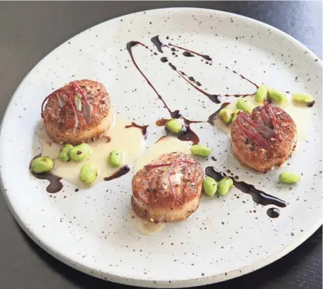  ?? MICHAEL SEARS / MILWAUKEE JOURNAL SENTINEL ?? Togarashi scallops with miso beurre monte and edamame is one of the plates for sharing at dinnertime at Belfre Kitchen, 606 N. Genesee St., in Delafield.