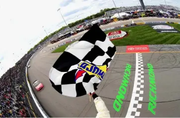  ?? Daniel Shirey/Associated Press ?? Kurt Busch takes the checkered flag to win the NASCAR race Sunday in Richmond, Va.