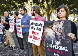  ?? RICHARD VOGEL / ASSOCIATED PRESS ?? Emily Rohr (right) joins fur ban protesters with the People for the Ethical Treatment of Animals on Tuesday at Los Angeles City Hall. Neighborin­g West Hollywood as well as Berkeley and San Francisco already have fur bans.