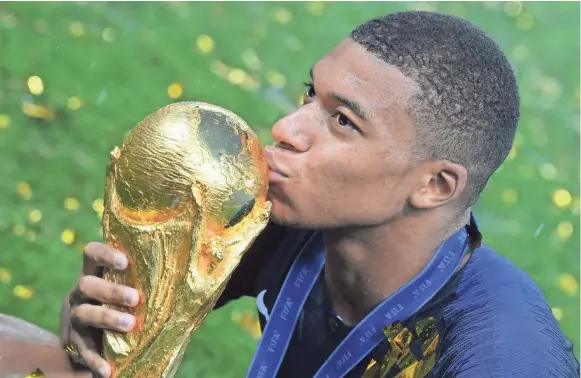  ??  ?? France forward Kylian Mbappe kisses the trophy after winning the World Cup final on Sunday. KIRILL KUDRYAVTSE­V/AFP/GETTY IMAGES