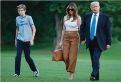  ?? —AP ?? WASHINGTON: US President Donald Trump, first lady Melania Trump, and their son Barron Trump walk from Marine One across the South Lawn to the White House on Sunday.