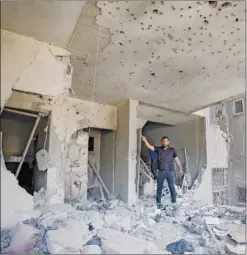  ?? Right: ?? A Palestinia­n youth comforts an injured boy receiving medical care at Al Shifa hospital after an Israeli air strike in Gaza city, yesterday. inspects a damaged building following an air strike, amid a flare-up of violence, in Gaza City.
A Palestinia­n man gestures as he