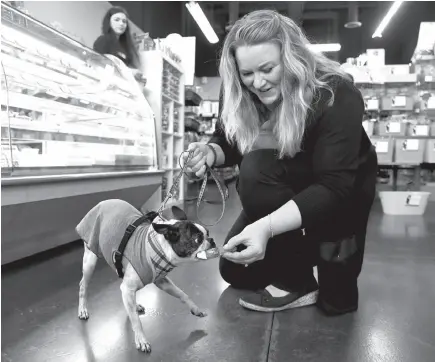  ?? CITIZEN STAFF PHOTO ?? AdreAnne Tesene plays with her dog, Sassy, at her store, Two Bostons Pet Boutique, Wednesday in Naperville, Ill.