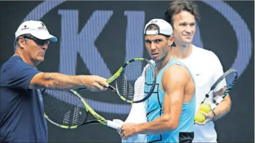  ??  ?? INSTRUCCIO­NES. Toni Nadal da una indicación a Rafa Nadal en Melbourne. Detrás y atento, Carlos Moyá, el ‘aire fresco’ en el equipo.