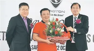  ??  ?? PILIHAN TERBAIK: Tan (kanan) menyampaik­an hadiah kepada seorang pelanggan (tengah) yang baharu sahaja menempah Proton X70, sambil disaksikan oleh Dr Ho Tuck Sum (kiri).
