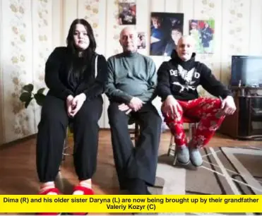  ?? ?? Dima (R) and his older sister Daryna (L) are now being brought up by their grandfathe­r Valeriy Kozyr (C)