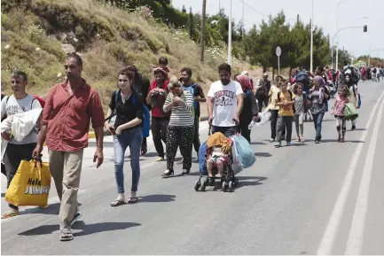  ?? (Reuters) ?? REFUGEES AND migrants from the Moria camp on Lesbos, in Greece, march toward Mytilene during a protest this week over the camp’s conditions.