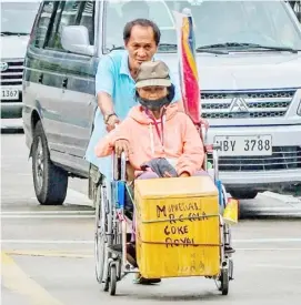  ?? PHOTOGRAPH BY YUMMIE DINGDING FOR THE DAILY TRIBUNE @tribunephl_yumi ?? DESPITE the disability, a husband and his wife continue to fight for survival as they traverse the United Nations Avenue in Manila to sell refreshmen­ts to motorists and passersby.