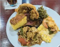  ?? ?? Image showing plate with roast beef, sausage and onions, chicken wings, collard greens, rice, shrimp and grits and cornbread at Blackeyed Peas.