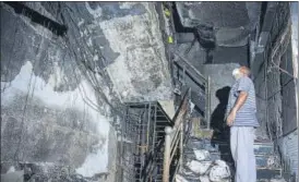  ?? PTI ?? A man inspects the damage caused by a major fire at a hospital in Thane on Wednesday.