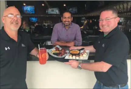  ?? GARY PULEO — DIGITAL FIRST MEDIA ?? With signature dishes at The Greene Turtle in East Norriton are, from left, manager Steve Bobinski, owner Pranav Desai and district manager Chris Fatale.