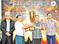  ??  ?? Siringan (second right) presenting the trophy of the annual sports championsh­ip organized by his ministry to a representa­tive from the Department of Human Resource Developmen­t, which emerged as the overall champion, while Vun (left) and others look on.