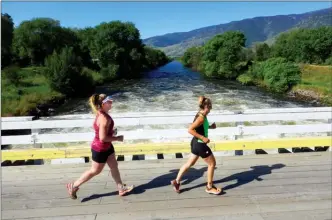  ?? STEVE MACNAULL/The Okanagan Weekend ?? Oliver runners Cheryl Gillson, front, and Naomi Garrish are excited for the Oct. 1 Baldy Marathon and its 10kilometr­e, 20-kilometre and full-marathon routes, which follow the picturesqu­e Okanagan River. Here, they cross one of the many bridges that...