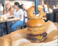  ??  ?? The best-selling Lockhart Legend burger is topped with applewood smoked bacon, cheddar cheese, Dr Pepper BBQ sauce and onion rings.