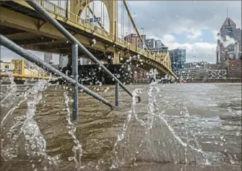  ?? Lake Fong/Post-Gazette ?? Water splashes on the steps of the North Shore Trail as Downtown can be seen in the background Friday.