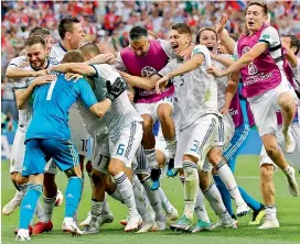  ?? —AP ?? Russian players rush to hug goalkeeper Igor Akinfeev (left) after he makes a save during the penalty shootout against Spain at the Luzhniki Stadium in Moscow on Sunday.