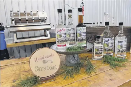  ?? Photos by Lori Van Buren / times union ?? Pick Six vodka can be found in 300 retail stores in upstate new York. At left, cases of Pick Six vodka and a tank of the unfiltered spirit are seen at Courage distillery in Greenfield Center.