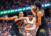  ?? PHIL LONG/THE ASSOCIATED PRESS ?? Memphis Grizzlies’ Scotty Pipen Jr., center, is defended by Cleveland Cavaliers’ Jarrett Allen, right, and Isaac Okoro on Wednesday in Cleveland. The Cavaliers won 110-98.