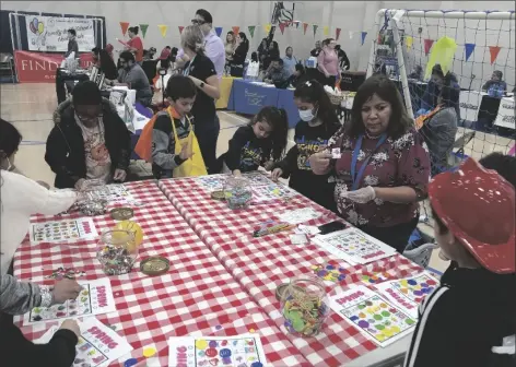  ?? ?? ABOVE: Students of Calipatria Unified School District play “Safety Bingo” with bingo caller and Director-Coordinato­r Maria Nava-Froelich (second from right), of the Calipatria-Niland Family Resource Center, at the agencies’ 20th annual Children’s & Families Health Fair, on Wednesday, March 15, at Grace Smith Elementary School in Niland.