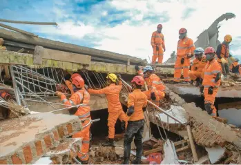  ?? TIMUR MATAHARI/GETTY-AFP ?? Indonesia earthquake: Rescue workers look for victims under collapsed buildings on Tuesday in Cianjur, Indonesia, following a powerful earthquake Monday on the island of Java. At least 268 people were killed, a figure expected to increase, and more than 1,000 hurt in the 5.6 magnitude temblor that was felt some 70 miles away in the capital, Jakarta.