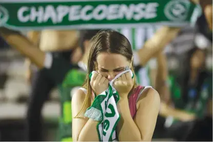  ?? | AP ?? A fan of the Brazilian soccer team Chapecoens­e mourns Tuesday at a gathering inside the team’s stadium in Chapeco.