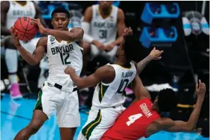  ?? The Associated Press ?? ■ Baylor guard Jared Butler (12) passes over teammate guard Adam Flagler (10) and Houston forward Justin Gorham (4) during the first half of Saturday’s men’s Final Four NCAA semifinal game at Lucas Oil Stadium in Indianapol­is.