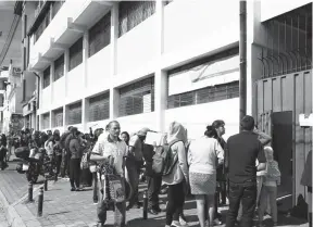  ??  ?? TRÁMITE. Con planillas de servicios y cédulas padres solicitaba­n ayer el cambio en la escuela Simón Bolívar, en Quito.