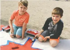  ??  ?? Grade 4 students Austin Madore and Max Alles paint the Canadian flag used in the Home Hardware video celebratin­g the countries 150th birthday and their patriotic paint line.