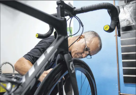  ?? Ellen Schmidt Las Vegas Review-Journal ?? Pro Cyclery employee Shane Broussard fixes a flat Wednesday. Tariffs have increased the cost of bicycles, their parts and shipping.